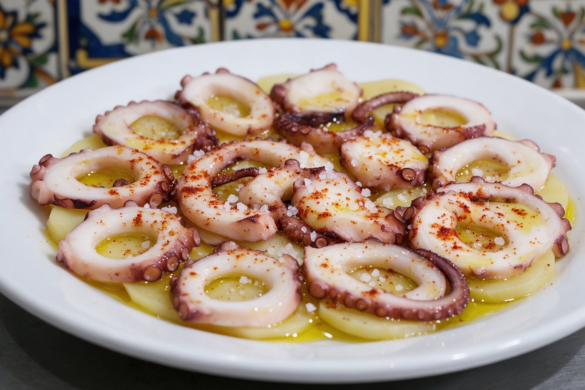Pulpo a la gallega en rodajas sobre patata con pimentón y aceite de oliva